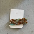 Detail of twisted acetate hair clips with blue and brown marble pattern on white card - Twisted Clips / Red and Blue