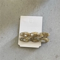 Detail view of tortoiseshell acetate twisted hair clips on a white card display - Twisted Clips / Grey Iridescent