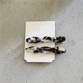 Detail of twisted acetate hair clips in marble texture on a white display card - Twisted Clips / Black & White