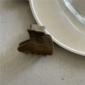 Dettaglio di un mollettone per capelli in resina marrone con scritta dorata Amy Bear Handmade - Marrone