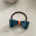 Details des blauen Acetat-Haargummis mit orangefarbenem Kontrast und Goldbeschriftung - Dunkelblau