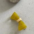Detaillierte Nahaufnahme einer gelben Acetat Schleife Haarklammer mit goldenem Metallclip - Gelee Gelbgrün