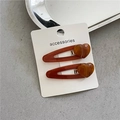 Detail of amber heart resin hair clips with marble texture on metallic BB clip base - Brown