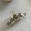 Détail de la pince à cheveux avec perles marbrées grises et ressort en métal doré - Gris