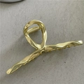 Dettaglio molletta per capelli in metallo liquido dorato con struttura in lega intrecciata - Oro Opaco