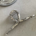 Detail of silver liquid metal hair claw showing anti-slip teeth and sleek fluid design - Bright Silver