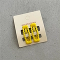 Dettaglio di fermagli BB ondulati in metallo giallo su carta per accessori - Giallo