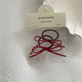 Détail de chouchous à nœud en daim bordeaux sur carte d'accessoires faits main - Bordeaux