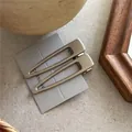 Dettaglio di fermagli per capelli geometrici in metallo argento opaco su cartoncino - Goccia Triangolare (J3.5)