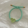 Detail of mint green braided hair tie featuring a heart charm and gold metal accents - Green