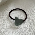 Detail of a Morandi green heart-shaped resin charm on an elastic black hair tie band - Grey Green