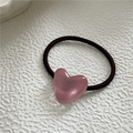 Detail of a brown elastic hair tie featuring a smooth pink heart resin decoration - Pink
