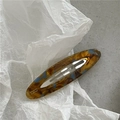 Close-up of tortoise shell acetate hair clip with blue accents and handmade lettering - Oval BB Clip / Glazed Multi-color