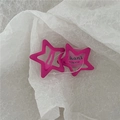 Primer plano de pinzas de pelo rosa mate con forma de estrella en papel crepé - Rosa Roja