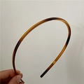 Close-up of tortoise shell resin headband with non-slip teeth for secure hairstyling - Thin Tortoiseshell