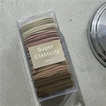 Pack of 10 elastic hair ties in earthy tones like beige and brown in a clear box - Dark Coffee Bean Purple
