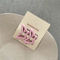 Dettaglio di graziose mollette a farfalla in plastica rosa opaco su espositore - Rosa Chiaro