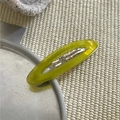 Dettaglio di un fermaglio per capelli ovale traforato in acetato verde-giallo traslucido - Giallo e Verde