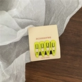 Detail view of 4-pack lime green metal snap hair clips on cardboard display card - Yellow & Green