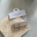 Détail d'un ensemble de six barrettes dorées avec strass présentées sur une carte - Strass Doré