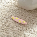 Close-up of pink alloy hair clip with yellow butterfly patterns on soft fabric background - Pink