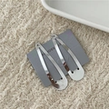 Dettaglio di due fermagli per capelli minimalisti in lega argento su carta grigia - Clip BB Goccia d'Acqua Argento