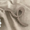 Detail of coffee brown large hair claw clip with matte finish on textured fabric - Wave Cross Claw Clip / Light Coffee