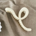 Detail view of cream white matte hair claw clip with minimalist twisted geometric lines - Wave Cross Claw Clip / Beige