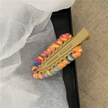 Dettaglio dell'intreccio in filato colorato su un fermaglio a goccia color kaki - Giallo Cachi