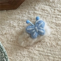 Détail d'une pince à cheveux papillon en peluche bleue sur base en fausse fourrure - Papillon Bleu Style Peluche Blanc