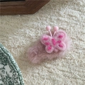 Gros plan d'une pince à cheveux en peluche rose avec un papillon brodé en feutrine - Papillon Rose Style Peluche Rose