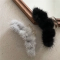 Detail showing soft black and grey plush hair claws with fur pom poms on a textured surface - Type I Long Faux Mink Fur (Random Color) (F7.5)