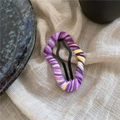 Vista macro della trama colorata in lana lavorata a maglia sulla clip in metallo a nuvola - Viola