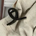 Detail of dark green velvet hair claw clip on beige fabric with a textured finish - Dark Green Flocked Small Hair Claw (F7.5 -G)