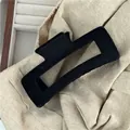 Close-up of a large rectangular matte black plush hair claw clip on soft beige fabric - Black Flocked Rectangular Hair Claw (G7.5 -J)