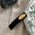Dettaglio del fermaglio per capelli in velluto nero vintage con etichetta dorata handmade - Nero