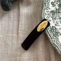 Dettaglio della scritta handmade su placca dorata e fermaglio per capelli in velluto marrone - Caffè Scuro