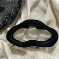 Macro shot of black flocked wave geometric claw clip on a soft textured linen background - Black Wavy