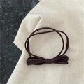 Détail de l'élastique à cheveux marron café avec double nœud sur tissu rustique - Nœud Papillon Café Foncé