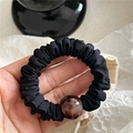 Close-up of black pleated hair scrunchie with a brown translucent amber-like resin bead - Black (Leopard Bead)