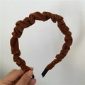 Detailed texture of caramel velvet pleated headband with soft fabric and protective ends - Brown