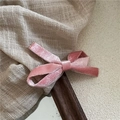 Detalle de pinza de pelo con lazo de terciopelo rosa sobre lino y fondo de madera - Rosa