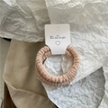 Detalle de gomas de pelo de felpa acanalada en tonos beige sobre fondo decorativo - Beige Plisado