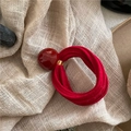 Detail van rode elastische haarelastiek met gladde kraal en gouden sluiting op linnen - Rood (Ronde Bal)