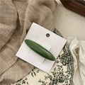 Détail d'une barrette en acétate vert olive avec marquage français sur sa carte - vert foncé