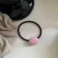 Close-up of pink oval pebble hair tie with dark brown elastic cord on a textured base - Oval Rubber Band / Pink (Lacquer)