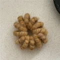 Close-up of a brown wool-wrapped spiral phone cord hair tie with soft plush texture - Yellow