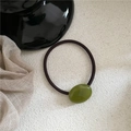 Detail view of cream olive green oval pebble hair tie with glossy resin on textured surface - Oval Rubber Band / Translucent Green
