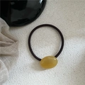 Detail of amber-colored resin pebble bead on high-elastic brown hair tie with soft texture - Oval Rubber Band / Transparent Yellow