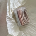 Détail d'élastiques à cheveux crème dans un récipient de rangement cylindrique - Gris/Blanc